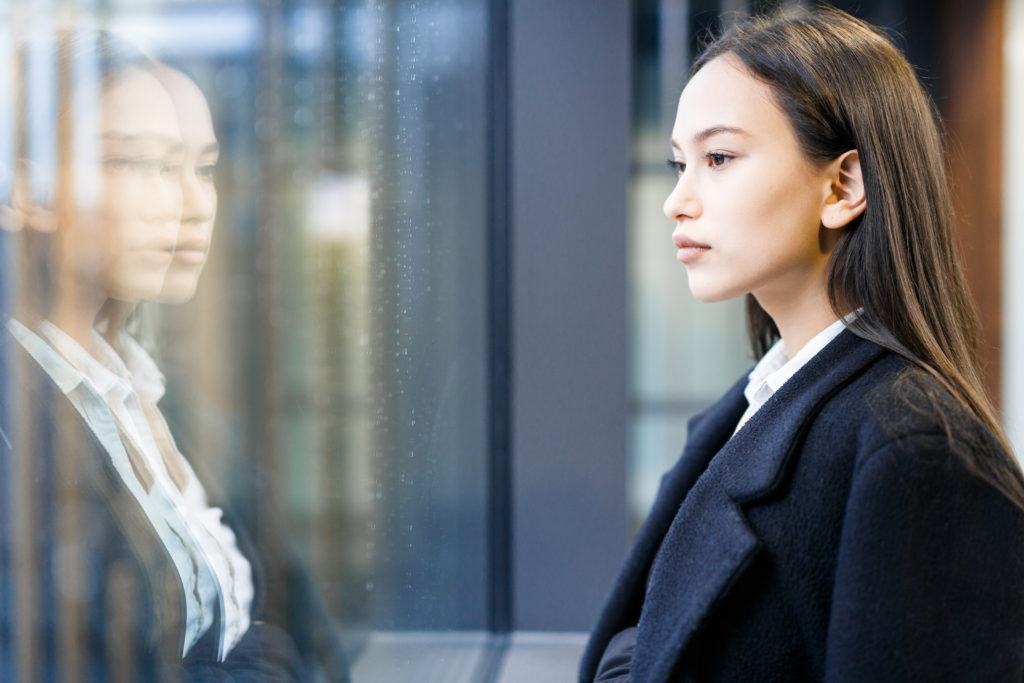 Young employee looking through office center window