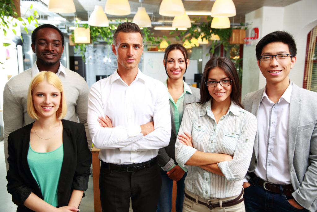 Group of a smiling businesspeople standing together in office